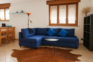 a blue couch in a living room with a table at Stephanie Residence in Esino Lario