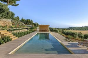 una piscina en medio de un jardín con árboles en OLIViA dimora, en Noto
