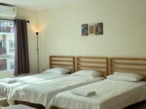 two beds sitting next to each other in a room at Jira cozy room Suvarnabhumi Airport 15mins in Lat Krabang +15 photos