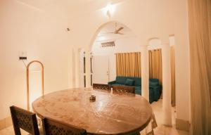 a dining room with a table and a green couch at White Lotus Homestay in Dibrugarh +15 photos