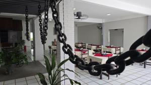 a chain hanging in a restaurant with tables and chairs at Hotel Terra do Sal in Mossoró