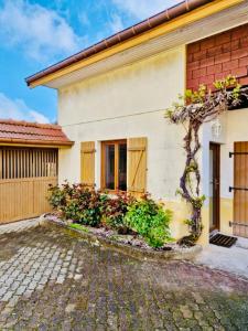 a house with a tree in front of it at Très joli logement in Anould