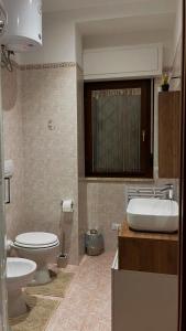 a bathroom with a toilet and a sink at La Coccola in Santa Maria delle Mole