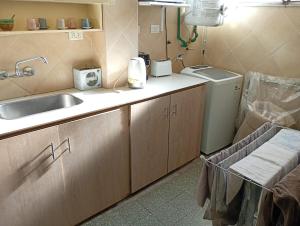 eine Küche mit Spüle und Waschmaschine in der Unterkunft Emilia in Barraquero