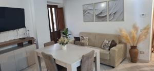 a living room with a white table and a couch at SoLe Apartment in Campagnano di Roma