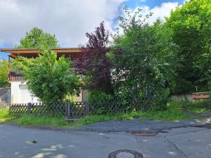 a fence in front of a house with trees at Ferienhaus Ottilie in Gladenbach