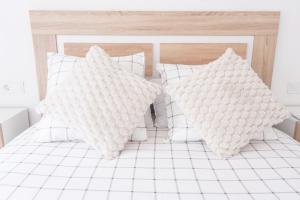 a white bed with white pillows on it at Apartamento Cassa de la selva in Cassà de la Selva