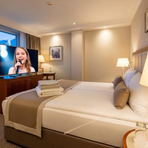 een hotelkamer met een vrouw die in een microfoon spreekt bij Baku Khatai Hotel & Restaurant in Baku