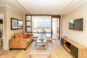ein Wohnzimmer mit Sofa und Tisch in der Unterkunft Opulent Heights - Katherine Quay Sandton in Johannesburg