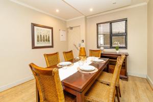 ein Esszimmer mit einem Holztisch und Stühlen in der Unterkunft Opulent Heights - Katherine Quay Sandton in Johannesburg