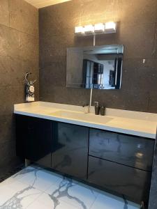 une salle de bain avec un lavabo et un miroir dans l'établissement Tu casa en Rosarito en Familia, à Rosarito Beach