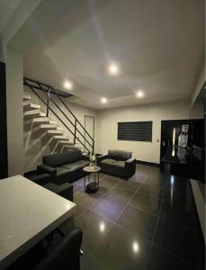 un salon avec un canapé et un escalier dans l'établissement Tu casa en Rosarito en Familia, à Rosarito Beach