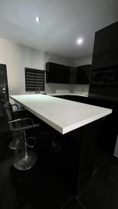 une grande table blanche dans une pièce avec des chaises dans l'établissement Tu casa en Rosarito en Familia, à Rosarito Beach