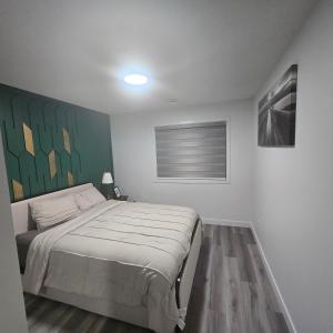a bedroom with a bed and a painting on the wall at The Walkout at the Ravine in Edmonton