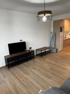 a living room with a flat screen tv and a wooden floor at Studio 200 m from the sea in Aguadulce