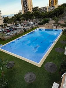 an overhead view of a large swimming pool with umbrellas at Studio 200 m from the sea in Aguadulce