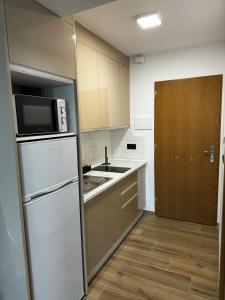 a kitchen with a white refrigerator and a microwave at Studio 200 m from the sea in Aguadulce