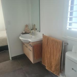 a bathroom with a sink and a mirror at Sandspit Hideaway in Sandspit