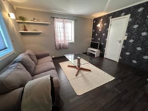 un soggiorno con un divano e un tavolo di vetro di 1-bedroom Apartment Near City Centre ad Ålesund