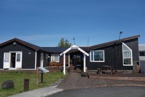 a black house with a wooden deck in front of it at Hotel Laki in Kirkjubæjarklaustur +123 photos