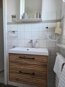 a bathroom with a sink and a mirror at Pension Zur Brandung in Büsum +80 photos