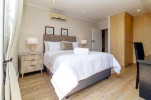 ein Schlafzimmer mit einem großen weißen Bett und einem Fernseher in der Unterkunft Opulent Heights - Katherine Quay Sandton in Johannesburg + 15 Fotos