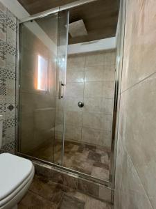a shower stall in a bathroom with a toilet at La Aruera in Salto +59 photos