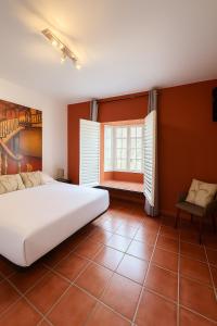 ein Schlafzimmer mit einem großen weißen Bett und einem Fenster in der Unterkunft Casa La Piedra in Badajoz