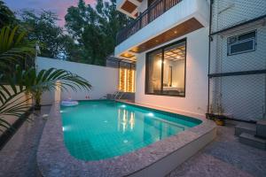 a swimming pool in the backyard of a house at 5BHK Villa With Pool & Theater Room in Malavli