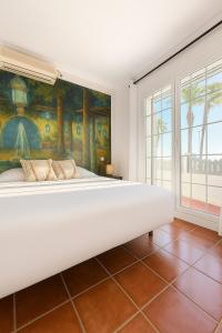 a large white bed in a room with a painting at Casa La Piedra in Badajoz