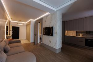 a living room with a couch and a kitchen at Modern Luxury Apartment 3 Inima Chisinaului in Chişinău