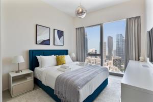 a bedroom with a bed and a large window at Luxury 4BR Full Burj khalifa & Fountain View, 1Gbps, PS5 in Dubai +189 photos