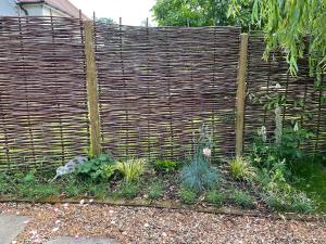 a wooden fence with plants in a garden at Mustard Pot Cottage in Eye