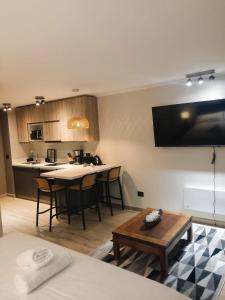 ein Wohnzimmer mit Tisch und Küche in der Unterkunft Apartamento Pucón in Pucón