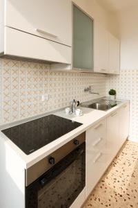 a white kitchen with a sink and a mirror at Pietra Ligure Sea View Parking & Bike Box in Pietra Ligure