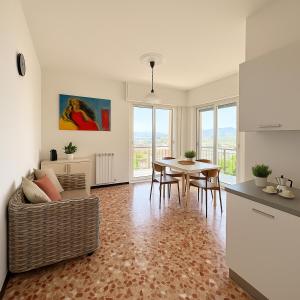 a living room with a table and a couch at Pietra Ligure Sea View Parking & Bike Box in Pietra Ligure