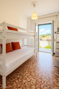 a bedroom with two bunk beds and a balcony at Pietra Ligure Sea View Parking & Bike Box in Pietra Ligure