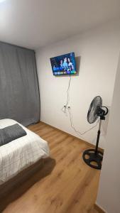 a bedroom with a bed and a television on the wall at LatinHouse Sevilla Baner in Seville