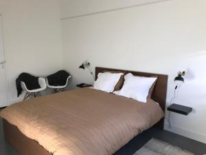 una camera da letto con un letto grande con due sedie di Bij Zelle a Garderen
