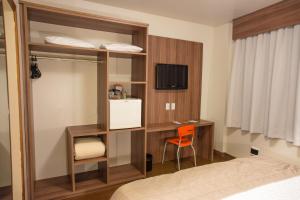 a bedroom with a bunk bed with a desk and a tv at Hotel Continental Business - 200 metros do Complexo Hospitalar Santa Casa in Porto Alegre +28 photos
