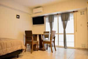 a bedroom with a table and chairs and a bed at Bnb Loft XVI in Rosario