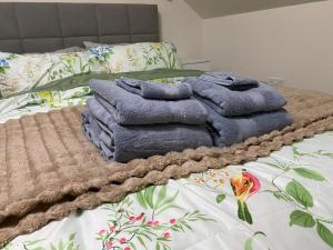 a pile of towels sitting on top of a bed at The Cottontail - Optional Hot Tub, Private Room, Free Continental Breakfast in Tamworth