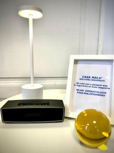 a lamp and a plate on a table next to a picture at Casa Malù, Corso Italia Piombino AC in Piombino