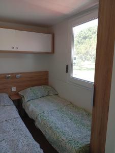 two beds in a small room with a window at Casetta sul mare in Lido di Classe