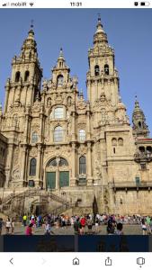 a large building with people standing in front of it at Hostal O Patron in Santiago de Compostela