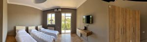 a room with a row of white beds at Nest Stay in Tbilisi City