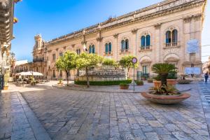 a large building with a plaza in front of it at Scicli Albergo Diffuso in Scicli