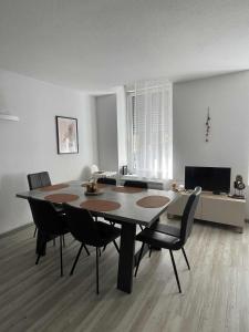 Una mesa de comedor y sillas en una sala de estar. en Appartement Souplex Centre de Cauterets, en Cauterets