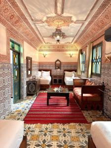 a room with a living room with two beds and a table at Riad Tasneem in Marrakesh
