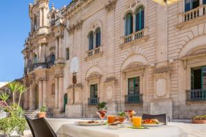 a table with plates of food in front of a building at Scicli Albergo Diffuso in Scicli